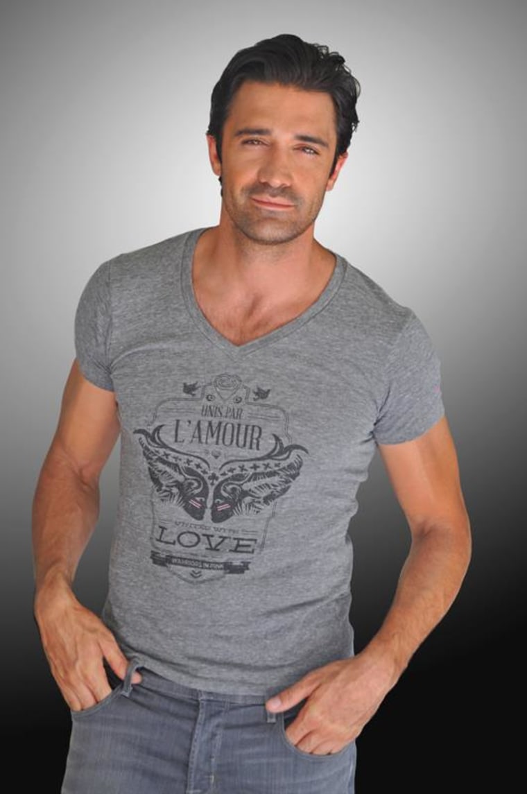 Giles Marini poses in a T-shirt that supports research for breast cancer.