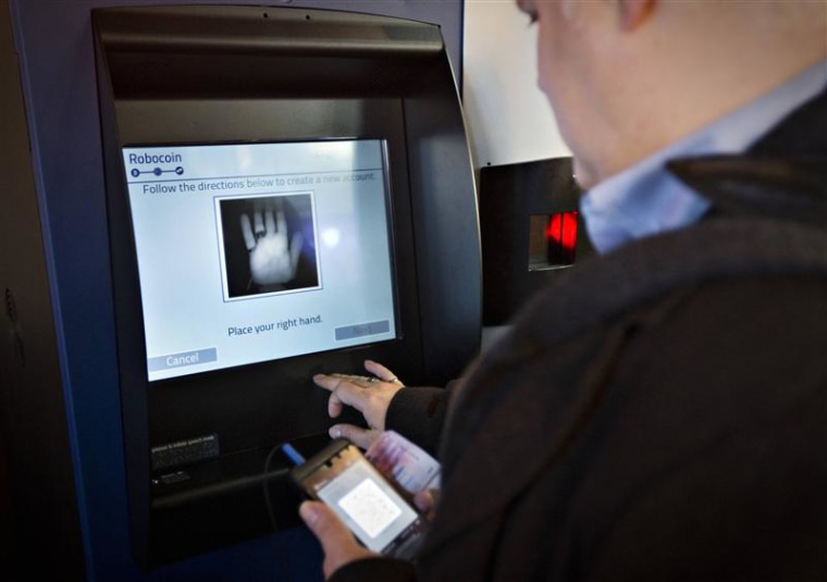 A customer registers his hand print before proceeding on the world's first ever permanent bitcoin ATM unveiled at a coffee shop in Vancouver, British ...