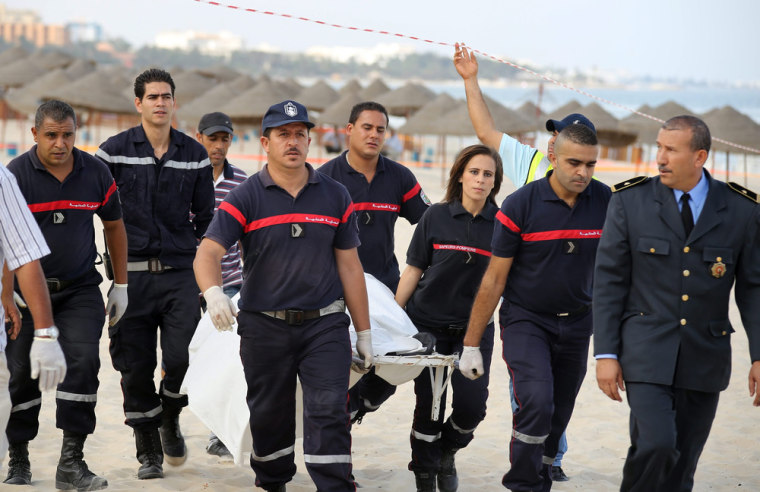 Tunisian members of the civil defense carry the corpse of a suicide bomber, who blew himself up at a beach near the tourist resort of Sousse.