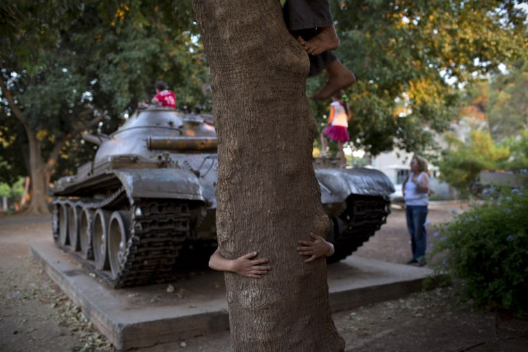 Children play on a Syrian T-62 tank placed as a memorial to fallen soldiers from the armored corps who were killed in the 1982 Israeli-Lebanese war, in the town of Petah Tikva, Aug. 1, 2013.