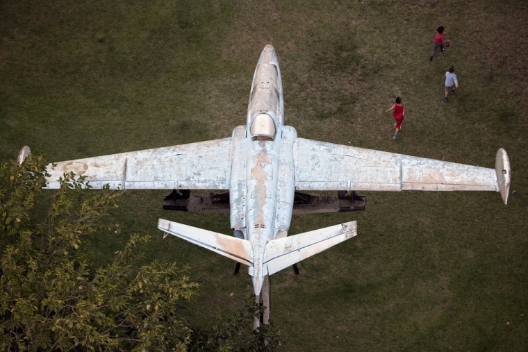 Children run in a playground near a Fuga aircraft placed as a memorial to fallen soldiers at the Air Force Garden in the central town of Givatayim, Oct. 21, 2013.