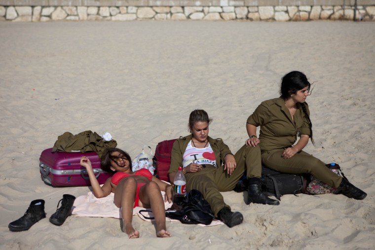 Soldiers sit on the beach in Tel Aviv, June 24, 2012.