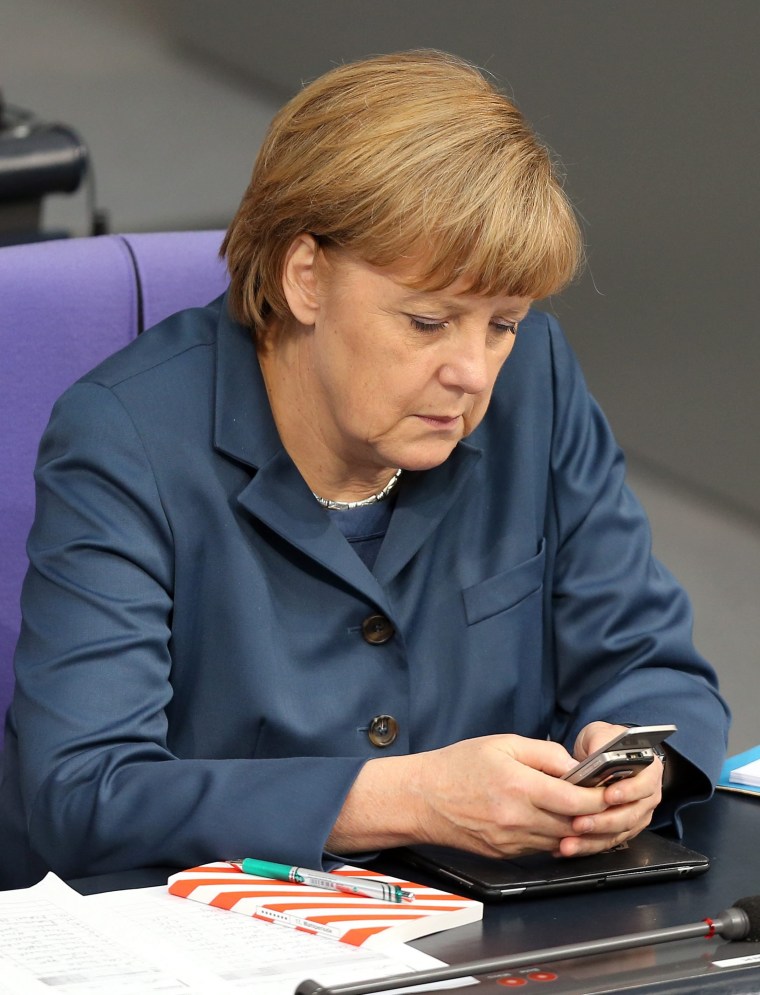 epa03927009 (FILE) A file picture dated 18 April 2013 shows German Chancellor Angela Merkel with her mobile phone in the German Bundestag parliament i...