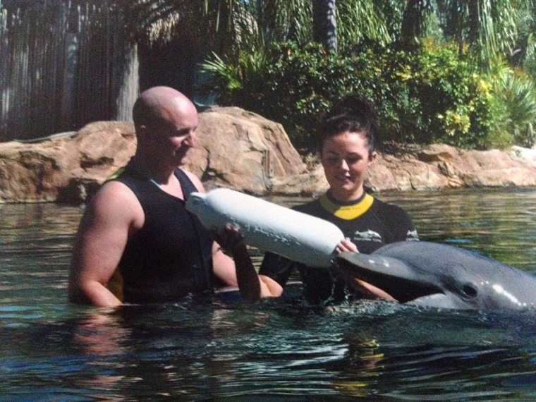 Alex Rigby pops the question to his girlfriend of three years with the help of a dolphin who delivered a personalized buoy.