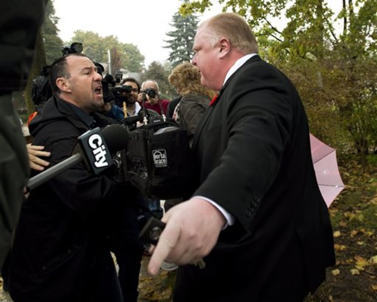 Toronto Mayor Rob Ford tells the media to get off his property as he leaves his home in Toronto on Thursday.