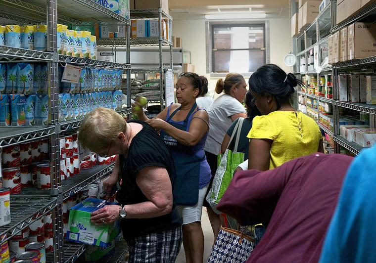 Volunteers help food bank clients in the pantry of the West Side Campaign Against Hunger food bank in New York City. The food bank assists thousands of qualifying New York residents in providing a monthly allotment of food.