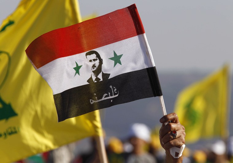 A supporter of Lebanon's Hezbollah waves a Syrian flag depicting Syria's President Bashar Assad during a 2011 rally in southern Lebanon.