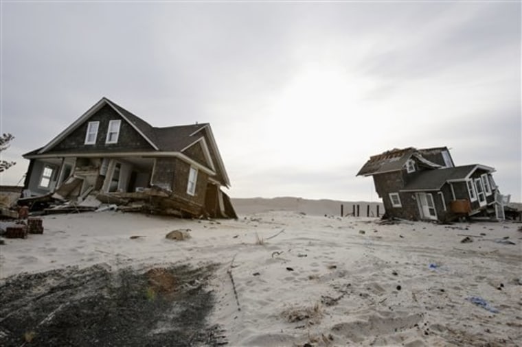 FILE - This Feb. 22,2013 file photo shows Two heavily damaged homes on the beach in Mantoloking, N.J., from Superstorm Sandy. Man-made global warming ...