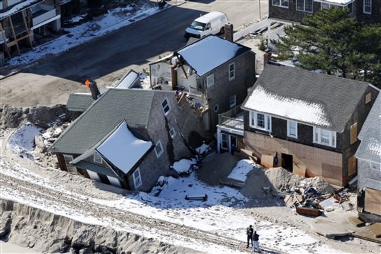 FILE - In this Nov. 9, 2012 aerial-file photo, people stand near damaged homes along the Atlantic Ocean in New Jersey after the region was pounded by ...