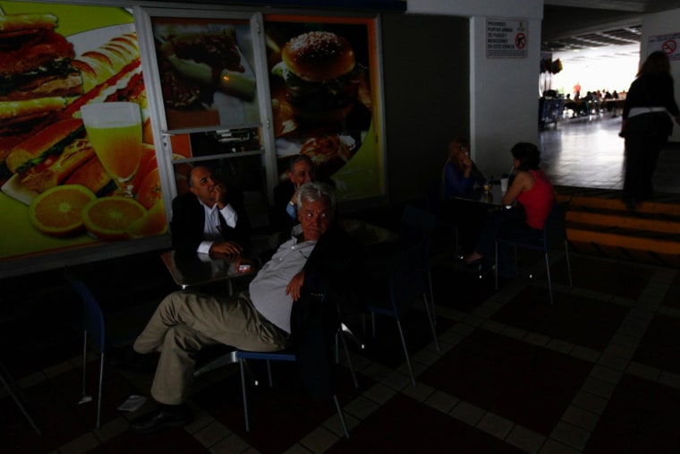People sit down to have lunch in darkness, during a massive blackout in Caracas September 3, 2013. A blackout hit much of Venezuela including the capital Caracas on Tuesday, but the oil industry was not affected and the government said it expected power to be restored within hours.