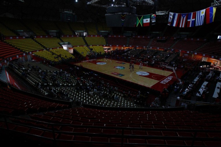 Players from Paraguay and Dominican Republic warm up while they wait for the power to return after a blackout during their FIBA Americas Championship basketball game in Caracas, Tuesday.
