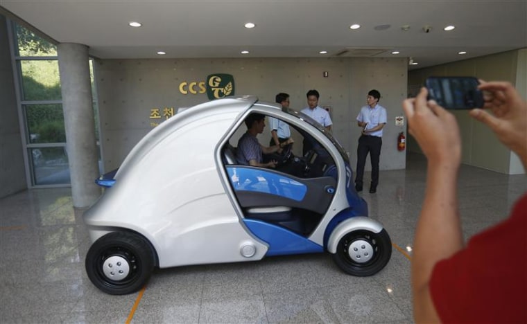 A visitor takes photographs of Armadillo-T, a foldable electric vehicle, at the Korea Advanced Institute of Science and Technology (KAIST) in Daejeon,...