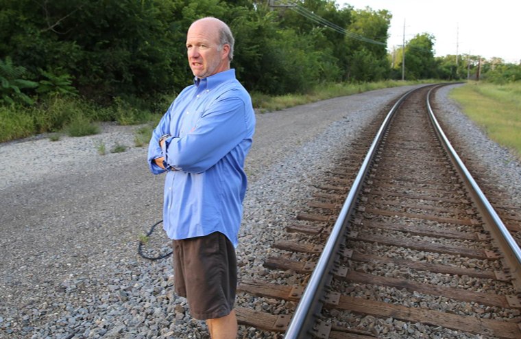 Steve Morrissey of Barrington, Ill., walks on the train tracks near his house. The boom in domestic oil and ethanol means that the number of freight trains rumbling through the heart of this Chicago suburb and past the window of his house has grown from five a day to nearly one an hour.