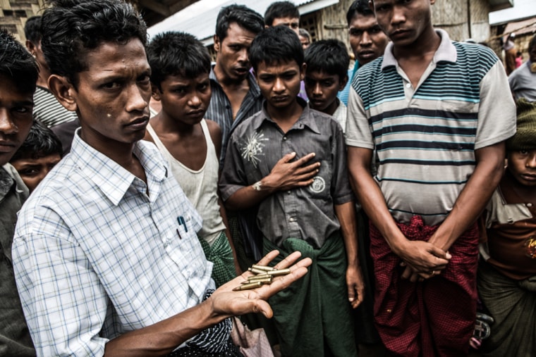 A Rohingya man holds bullets and casings left behind after police shot at a mob of camp residents who were demanding the dead body of one of their villagers.
