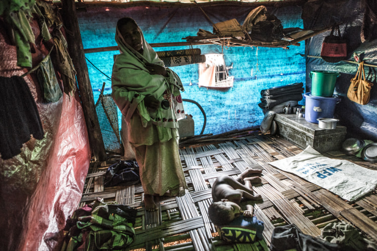 A Rohingya child naps in the searing midday sun inside his familiy's 10-foot by 10-foot room inside a shelter provided by aid groups.