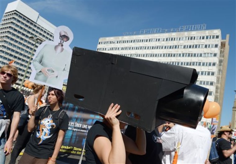 In this picture taken Sept. 7, 2013, a woman protests with a selfmade surveillance camera on her head during the demonstration 'in Berlin, Germany...