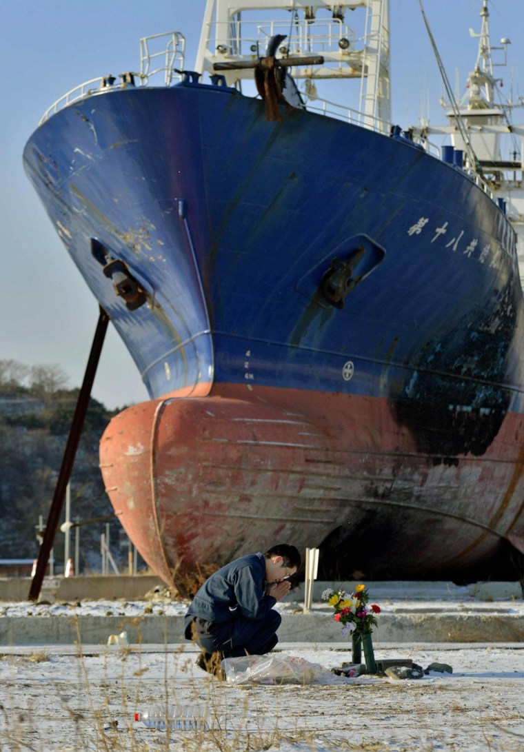 A man prays as he mourns victims of the 2011 earthquake and tsunami as a ship brought ashore by the disaster is seen in the background, in Kesennuma, Japan, in March this year.