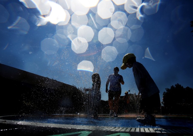 Children take refuge from the heat by playing in the fountain at the Kansas State Fair on Monday in Hutchinson, Kan.