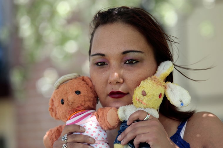 Inga, who was adopted from Russia, holds the two stuffed dolls she saved from the orphanage in Russia, near her apartment in Battle Creek, Mich., in May. She dressed the dolls in cloths she bought from a Michigan thrift shop.