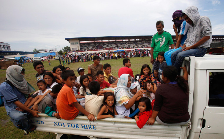 Residents arrive at a stadium that has been turned into a evacuation center after fleeing their homes due to fighting between Moro National Liberation Front rebels (MNLF) and government soldiers in Zamboanga city on Wednesday.
