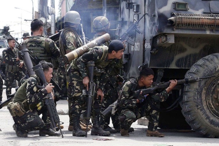 Filipino soldiers take up positions behind an armored personnel carrier (APC) during clashes in Zamboanga city, southern Philippines, on Wednesday.