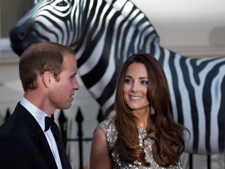 Britain's Prince William, left, and his wife Kate the Duchess of Cambridge are greeted as they arrive, in front of a model zebra, to attend the Tusk C...
