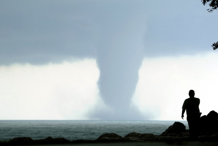 A person takes photos of a large water spout on Lake Michigan south east of Kenosha, Wis. on Sept. 12. At times two separate spouts were visible as clouds rotated.