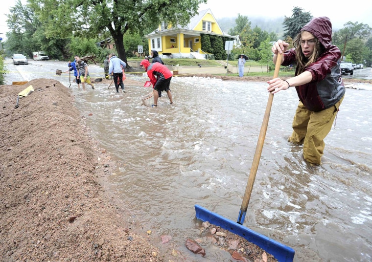 Nick Carter shovels debris into a dike as heavy rains cause severe flooding in Boulder, Colo., on Thursday.
