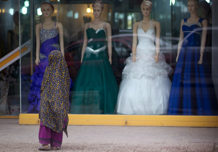 A girl stands in front of a woman's dress shop in the city of Kabul in April 2012. Freedom to find love and to choose a spouse is still elusive for women in Afghanistan.