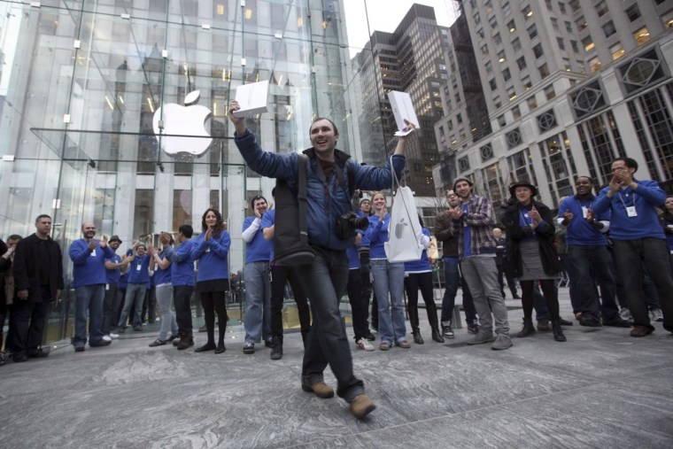 Alex Shumilov of Moscow is the first customer to walk out of the Apple store on Fifth Avenue in New York after purchasing two iPad 2s Friday, March 11...