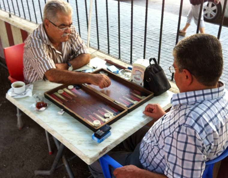 Two retired friends, Sammy Uksec and Sabah al-Din play backgammon at Antakya's Sumerler Café in Turkey.