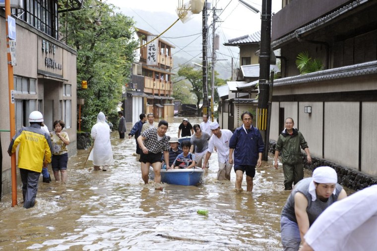 Hotel guests get a boat ride through a flooded street after the Katsura River in Kyoto overflowed.