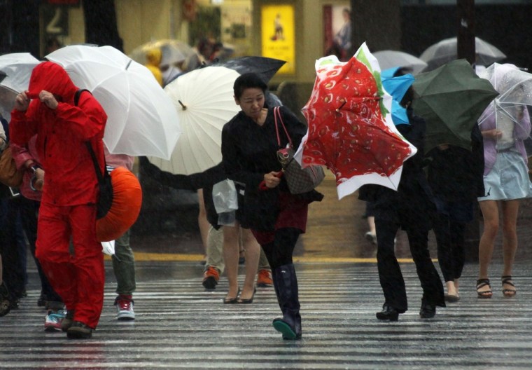 Pedestrians walk against strong wind and rain in Tokyo.