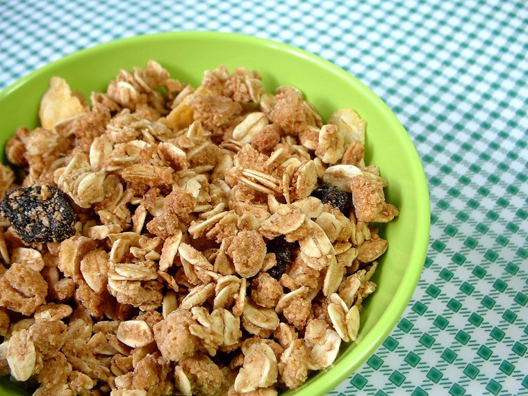 A close up view of a bowl full of granola on a chequered green towel.
