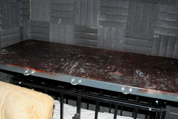 A steel cage with multiple locking devices, and a steel table top is shown in a room with acoustical sound-deadening material in a July 27, 2012 handout photo.