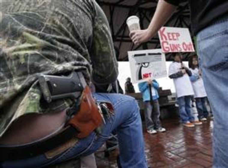 A customer is handed a Starbucks coffee drink as he sits with a handgun strapped to his belt while looking on at an anti-gun rally in Seattle in 2010.