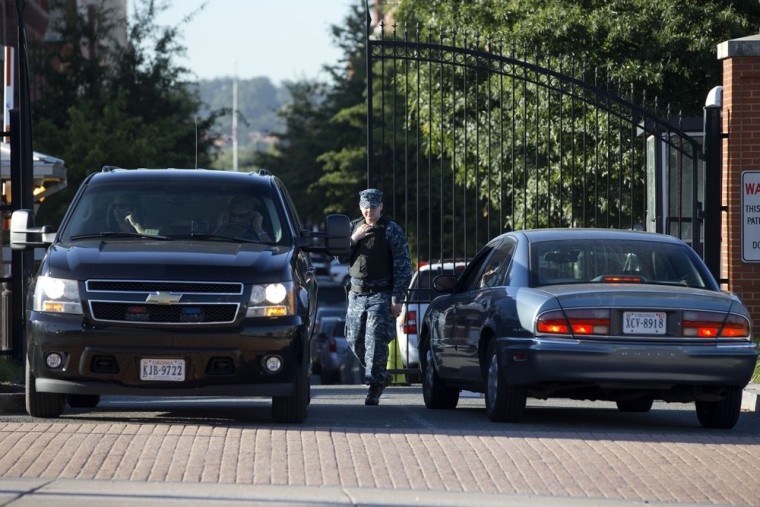 A member of the Navy checks vehicles at a gate to the Washington Navy Yard, as some employees return, many to retrieve their vehicles, two days after a gunman killed twelve people and was killed himself inside the Navy Yard in Washington, on Wednesday.