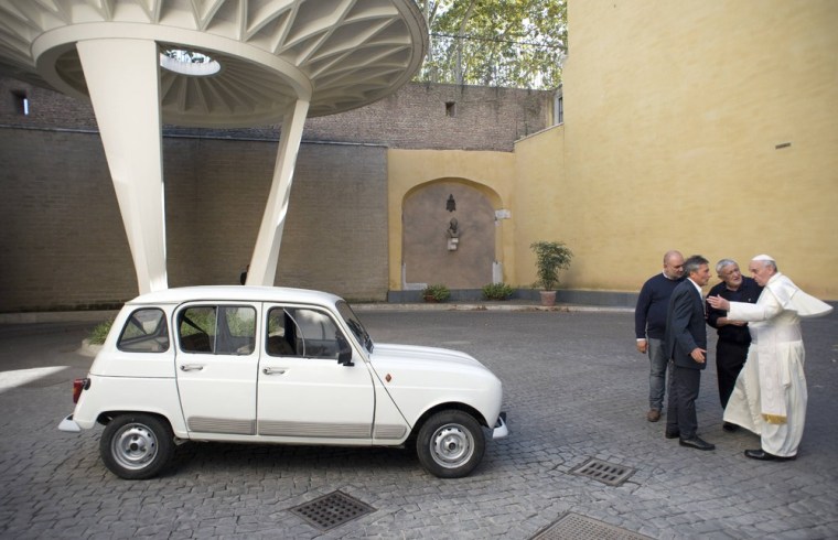 Pope Francis, right, is presented with a Renault 4 car during a private audience with Don Renzo Zocca at the Vatican on Sept. 7, 2013.