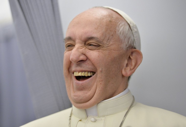 Pope Francis laughs while speaking to journalists travelling on the papal flight to Rio de Janeiro, on July 22.