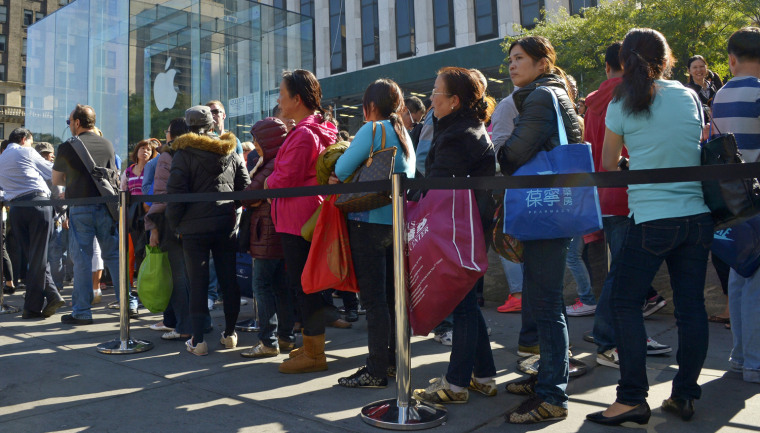 epa03875698 People wait in a line to buy new iPhones at an Apple store in New York, New York, USA, 20 September 2013. Apple released two new iPhones, ...