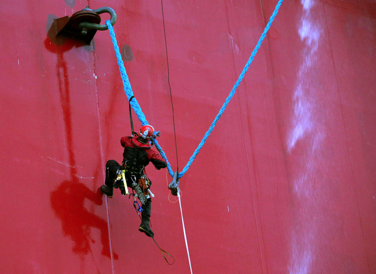 A handout photo taken by Greenpeace on September 18, 2013, shows a Greenpeace activist attempting to climb Gazprom's Prirazlomnaya Arctic oil platform.