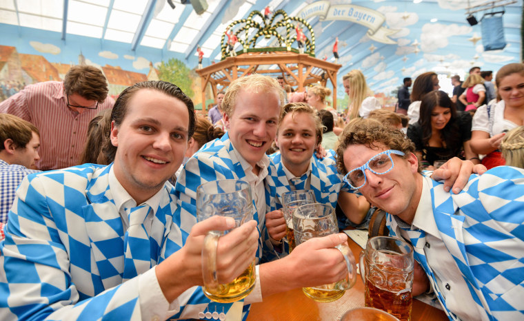 Visitors from the Netherlands raise their mugs in a beer tent on the opening day of Oktoberfest.