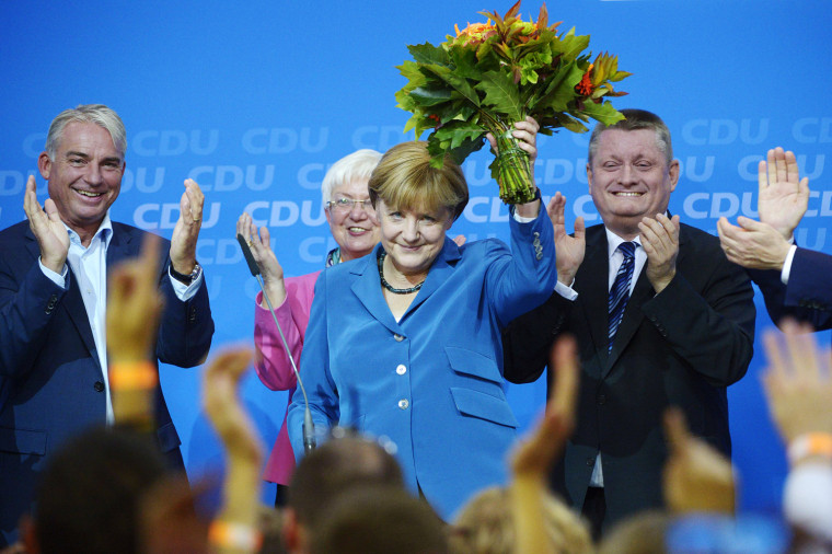 Angela Merkel holds flowers while being applauded after exit poll results were released on Sunday. Her party took 41.5 percent of the vote.