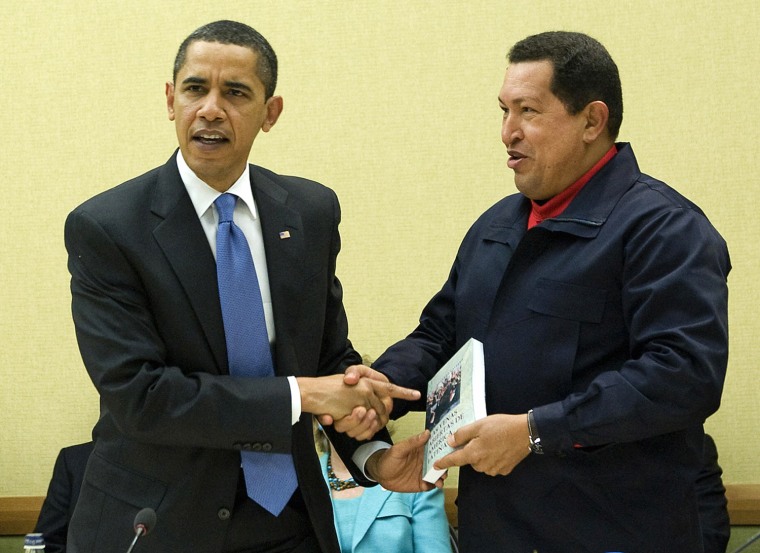 Venezuelan President Hugo Chavez shakes hands with President Barack Obama as he presents his with a book,