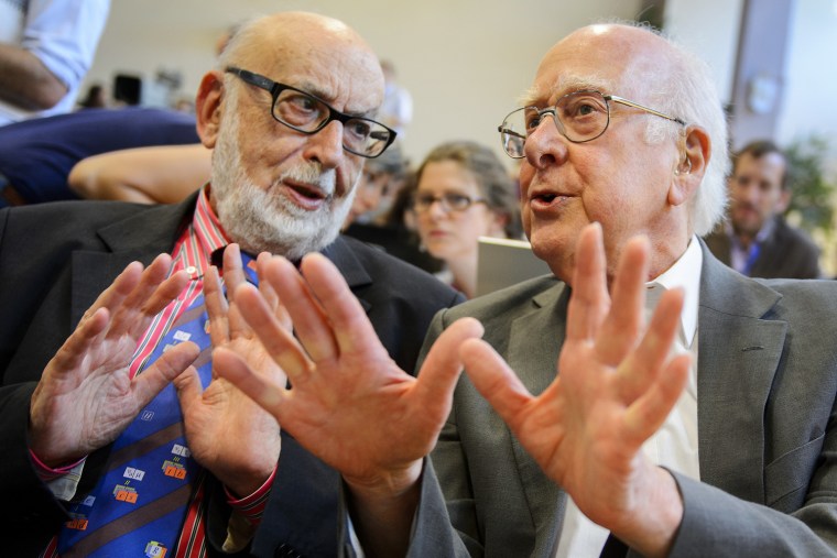 (FILES) This file picture dated July 4, 2012 shows British physicist Peter Higgs (R) speaking with Belgium physicist Francois Englert at a press confe...