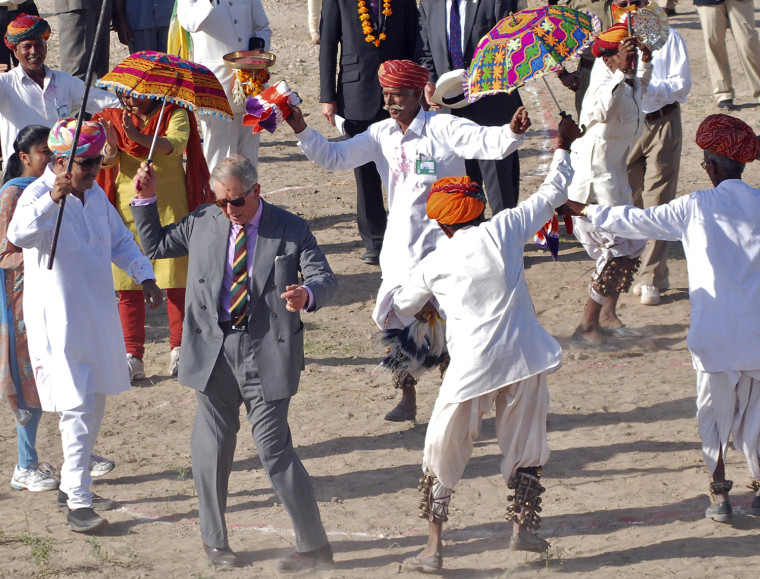 Britain's Prince Charles dances with villagers at Tolasar village near Jodhpur in India's state of Rajasthan October 5, 2010.  REUTERS/Sunil Verma (IN...