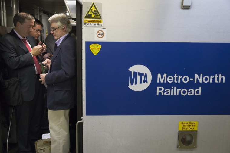 Commuters stand in the doorway of a Stamford-bound train at Grand Central Terminal as transit on the New Haven line runs on limited capacity on Sept. 25 in New York.