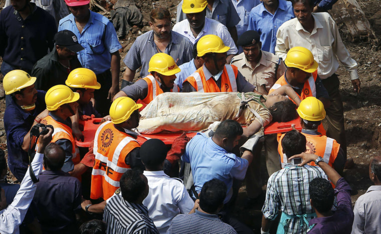 Rescue workers use a stretcher Friday to carry a woman who was rescued from the rubble at the site of a collapsed residential building in Mumbai, India.