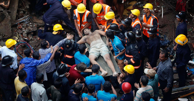 Rescue workers use a stretcher to carry a man who was rescued from the collapsed residential building in Mumbai, India on Sept. 27.