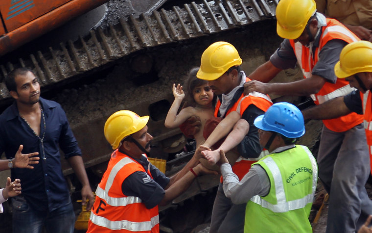 Rescue workers carry a girl out from the rubble of a building that collapsed in Mumbai, Sept. 27.